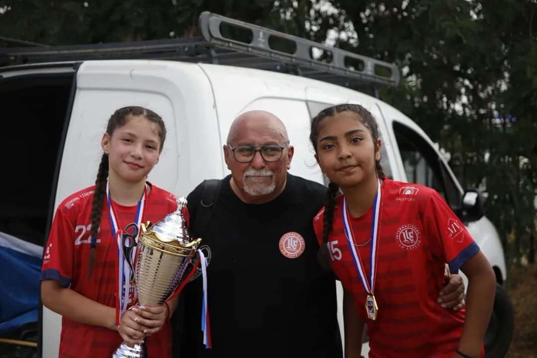 Dos campeonas con su profesor y la copa después de la premiación