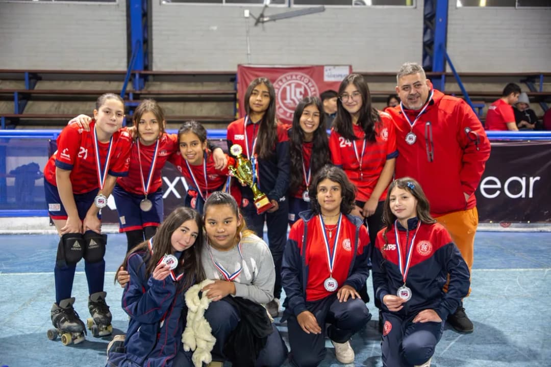Las jugadoras muestran sus medallas en el gimnasio junto a su entrenador
